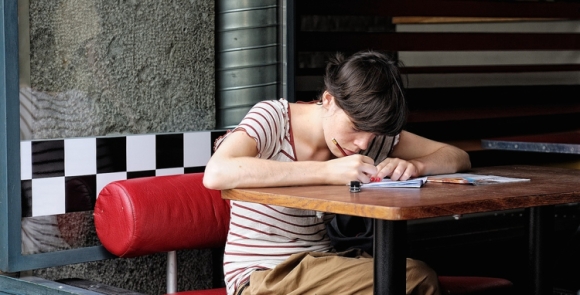 Girl writing in a cafe